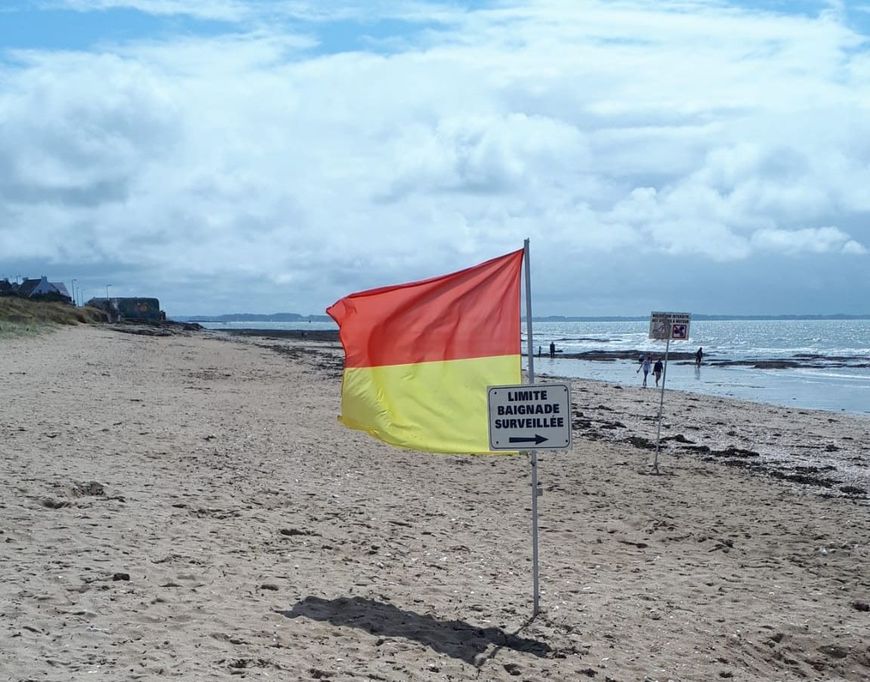 Le drapeau rouge et jaune délimite la zone de baignade sur la plage